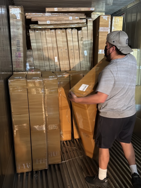 Equipo cargando contenedor con muebles